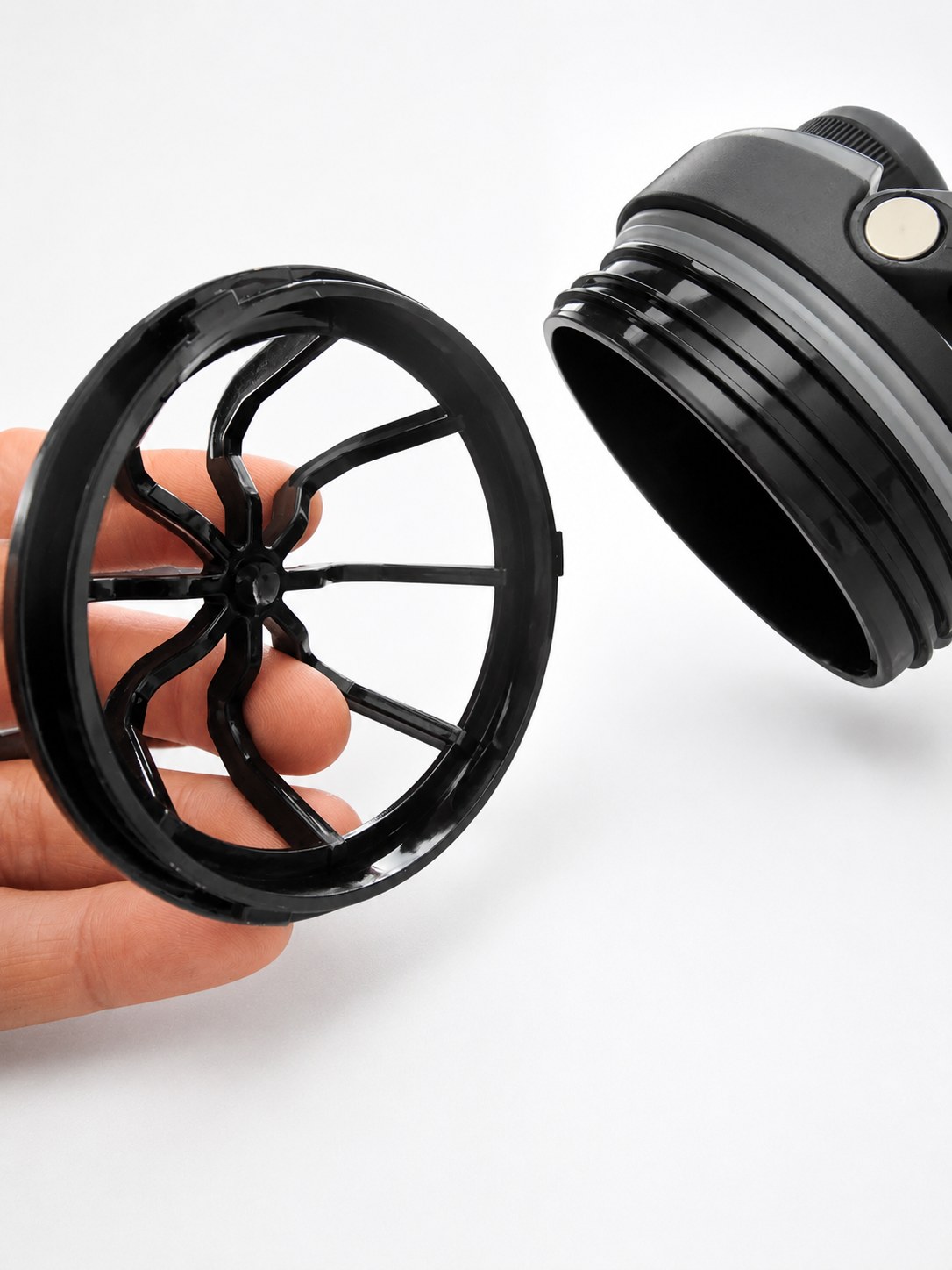 Removable PAKD Fuel Shkr agitator held in a hand next to the bottle lid