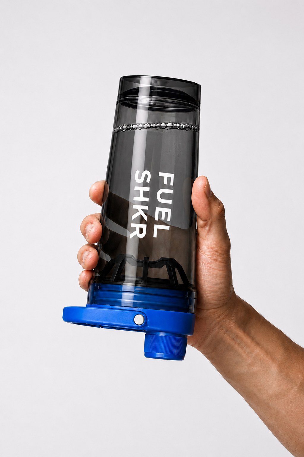 Hand holding the PAKD Fuel Shkr upside down, showing the agitator base
